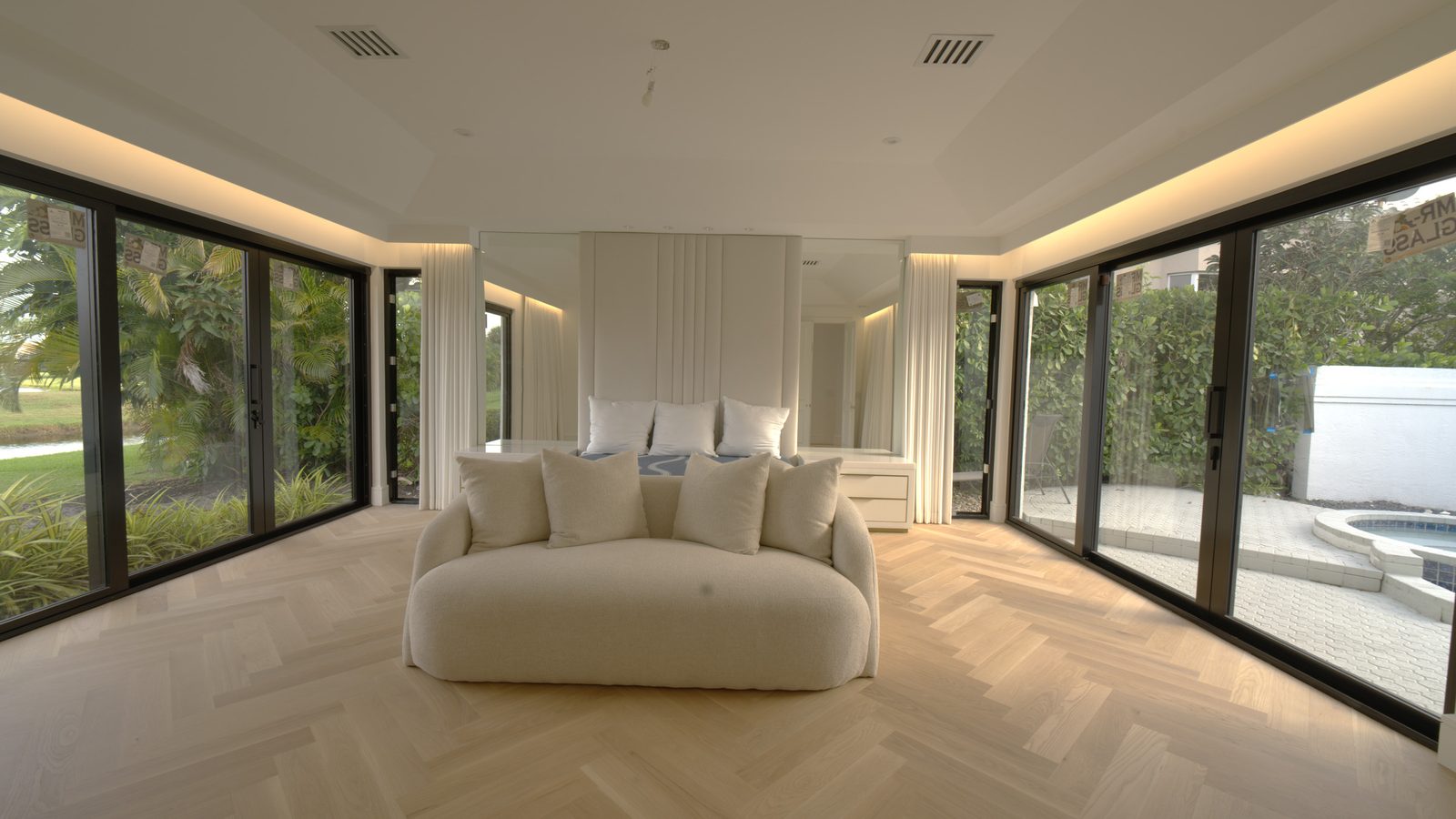 Boca Raton master bedroom with Kravet ripplefold drapery stacked open under a custom wood valance